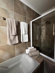 a bathroom with a tub and a shower and towels at Dan-à-La-Mer in Mossel Bay +40 photos