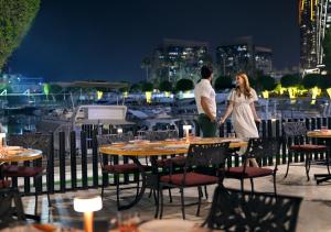 a man and a woman standing on a patio at night at InterContinental Abu Dhabi by IHG in Abu Dhabi +258 photos