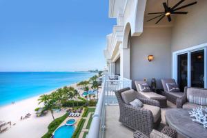 balkon z krzesłami i widokiem na plażę w obiekcie Beachcomber 36 w mieście George Town