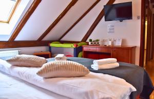 a bedroom with a bed with two pillows and a tv at Sobe Bimbo in Zaprešić