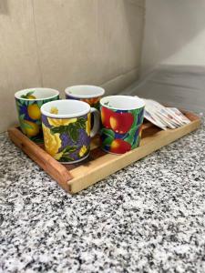 玛德琳港Casa Paso的柜台上的木托盘上放着三个杯子 更多1张照片
