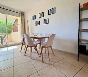 ヴァルラ・プラージュにあるVue piscine Appartement sympaのテーブルと椅子のあるダイニングルーム