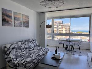 a living room with a couch and a table at La Coquille - Coquet T2 à 200m Juno Beach & Plage in Courseulles-sur-Mer