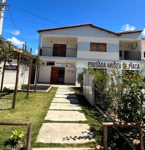 a house with a sign that reads pussula music piano at Pousada Museu de Piatã in Piatã