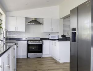 a white kitchen with white cabinets and a refrigerator at Hello Summer! 1-2 bedroom rate villa in Rodney Bay Village +19 photos