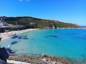 a view of a beach with people in the water at Case del centro storico Santa Teresa Gallura in Santa Teresa Gallura