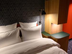 コペンハーゲンにあるHotel Frihavnenの白い枕が付いた大きなベッドのある寝室
