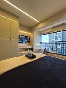 a bedroom with a large bed and a tv at Studio 1106 Raizes Tucuruvi- Proximo ao shopping in Sao Paulo +61 photos