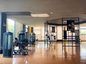 ein Fitnessstudio mit mehreren Laufbändern und Geräten in einem Raum in der Unterkunft Baylight Studio in Sampong