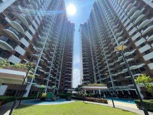 zwei große Apartmenthäuser mit einem Park davor in der Unterkunft Baylight Studio in Sampong