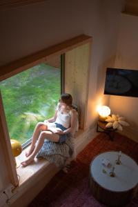 a woman sitting in a window in a room at Les Chalets de Seignou in Azet