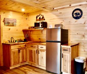 a kitchen with a stainless steel refrigerator and wooden cabinets at Lake Haven Motel in Lake George