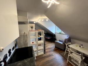 a living room with a staircase with a couch and a table at Gemütliches Apartment Würzburg-Heidingsfeld in Würzburg