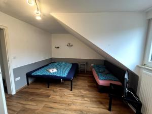 a attic room with two beds and a staircase at Gemütliches Apartment Würzburg-Heidingsfeld in Würzburg