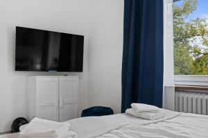 a bedroom with a bed with a television on the wall at HappyPlace - großzügige Ferienwohnung im Zentrum in Bad Wörishofen