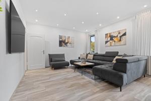 a living room with a couch and a table at HappyPlace - großzügige Ferienwohnung im Zentrum in Bad Wörishofen +13 photos