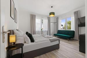 a bedroom with a bed and a green couch at HappyPlace - großzügige Ferienwohnung im Zentrum in Bad Wörishofen +19 photos