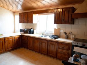 a kitchen with wooden cabinets and a sink and a window at Brisa do Nordeste in Nordestinho