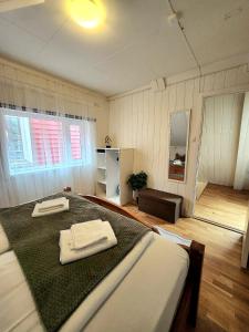 a bedroom with a large bed with two towels on it at Dali City Senter Ap 2 in Stavanger