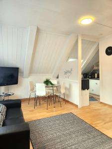 a living room with a couch and a table and chairs at Dali City Senter Ap 2 in Stavanger