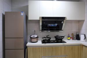 a kitchen with a stove and a microwave at Zhangjiajie 72 Wonder Tower Neighbour's House in Zhangjiajie +6 photos