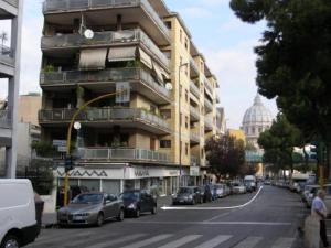 un gran edificio con coches aparcados en el lateral de una calle en Beside the Vatican, en Roma