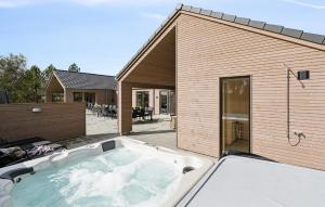 a hot tub in the backyard of a house at Cozy Home In Jerup With Sauna in Bratten Strand
