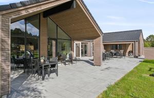 a patio with a table and chairs on it at Cozy Home In Jerup With Sauna in Bratten Strand