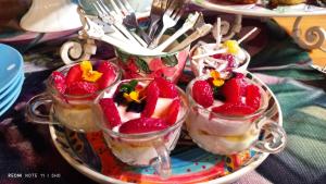 three cups of dessert on a plate with strawberries in them at Leopard Lily in Potchefstroom