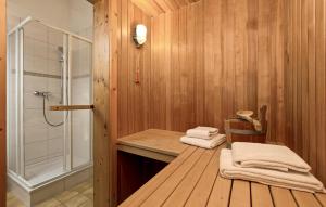 La salle de bains est pourvue de murs en bois, d'une douche et de serviettes. dans l'établissement Cozy Apartment In Rechlin With Sauna, à Zielow 16 autres photos