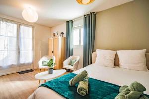 a bedroom with a bed with a green blanket on it at Studio - Calme - Confort - Proche de Tours in Monnaie