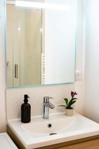 a bathroom sink with a mirror and a soap dispenser at Studio - Calme - Confort - Proche de Tours in Monnaie +16 photos