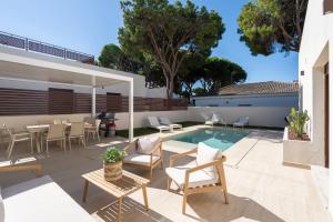 a patio with a table and chairs and a swimming pool at Casa Aura in Novo Sancti Petri