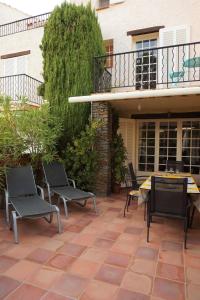 耶尔Maison Les Lauriers Roses vue sur le maquis de Porquerolles的建筑物前有椅子和桌子的露台 更多21张照片