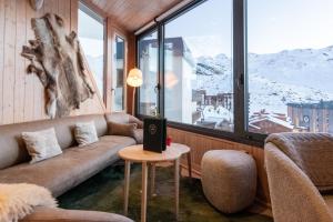 ヴァル・トランスにあるHôtel 3 Vallées - Appartements avec serviceのソファと大きな窓のあるリビングルーム