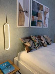 ein Schlafzimmer mit einem Bett und einem Tisch mit einem Buch in der Unterkunft Gravatá Flat no condomínio Monte Castelo MELHOR LOCALIZAÇÃO , Wi-Fi, SKY e AR in Gravatá + 20 Fotos