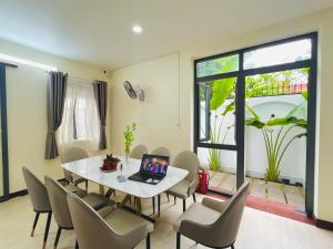 a dining room with a table and chairs with a laptop on it at Summer Villa Sai Gon in Ho Chi Minh City