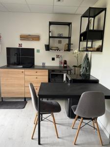 a dining room with a black table and two chairs at Peaceful apartment in Vierzon