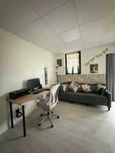 a living room with a desk and a couch at Peaceful apartment in Vierzon +1 photo