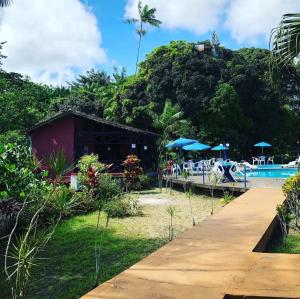 a resort with a pool and tables and umbrellas at Hotel Porto Arthur in Belém