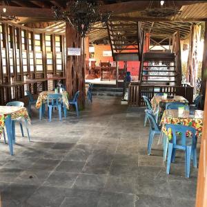 a dining room with tables and blue chairs in it at Hotel Porto Arthur in Belém