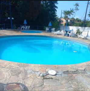 a large blue swimming pool with tables and chairs at Hotel Porto Arthur in Belém +36 photos