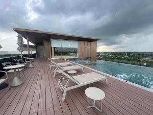 Una terraza con sillas y una piscina en un edificio. en The one ratchaphruek next to Ratchaphruek Road, en Ban Nong Bua
