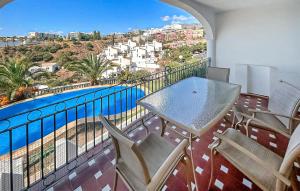 a balcony with a table and chairs and a swimming pool at 3 Bedroom Cozy Home In Fuengirola in Torremuelle