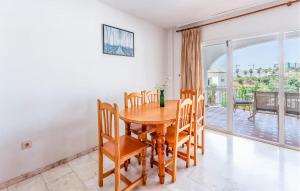 a dining room with a table and chairs and a balcony at 3 Bedroom Cozy Home In Fuengirola in Torremuelle