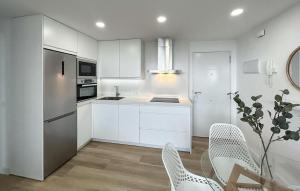 a kitchen with white cabinets and a table and chairs at 1 Bedroom Lovely Apartment In Benalmadena in Torremuelle