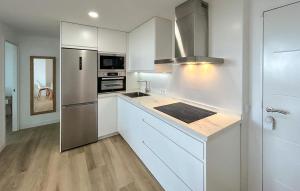 a kitchen with white cabinets and stainless steel appliances at 1 Bedroom Lovely Apartment In Benalmadena in Torremuelle