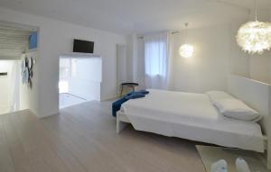 Un dormitorio blanco con una cama y una habitación con televisión. en Paradiso, en Pieve di Teco