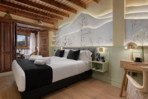 a bedroom with a large bed and a desk at KARAT El Nogal Hotel Boutique & Spa in Escalona