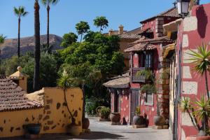 a street in a town with palm trees and buildings at KARAT El Nogal Hotel Boutique & Spa in Escalona